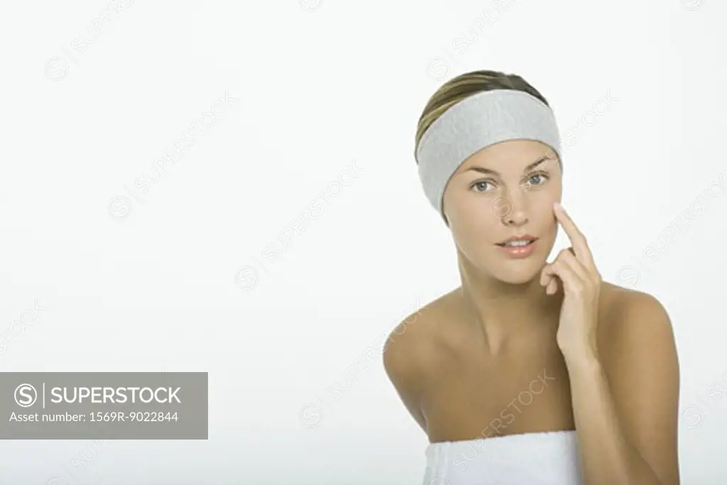Young woman touching cheek