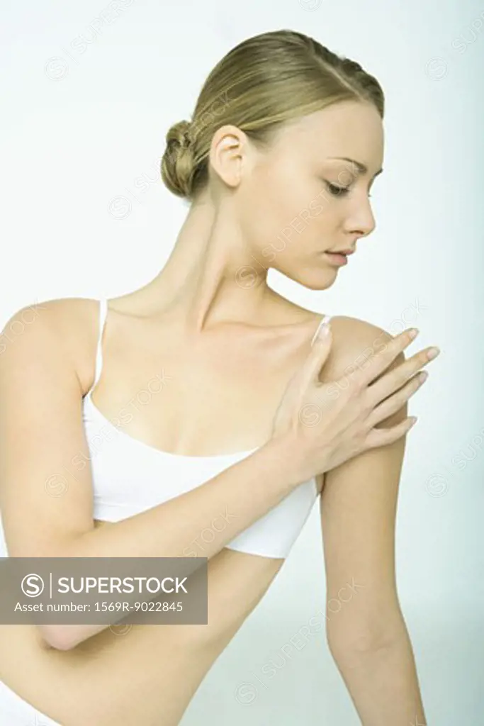 Young woman touching shoulder