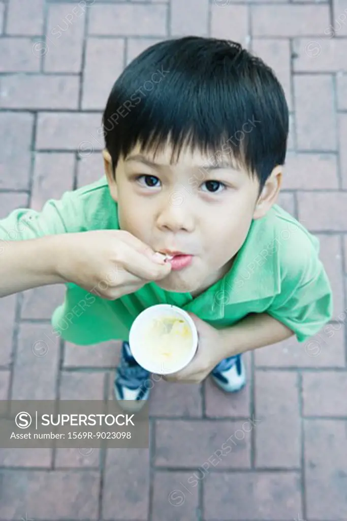 Boy eating sweet snack, smiling at camera