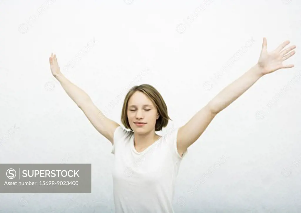 Teenage girl with arms out, eyes closed