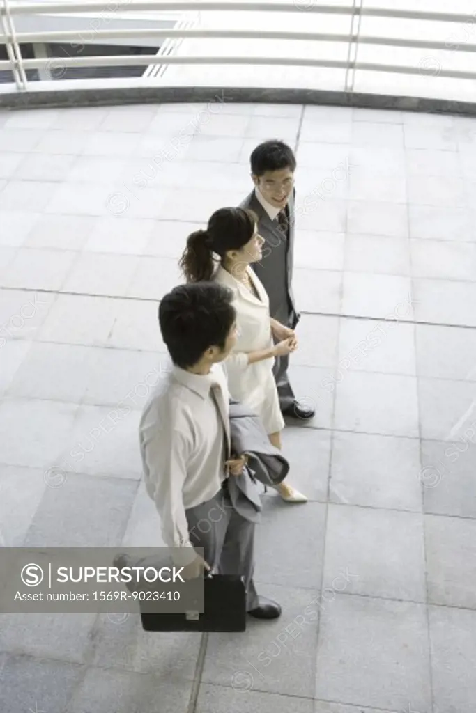 Three young executives walking side by side, high angle view