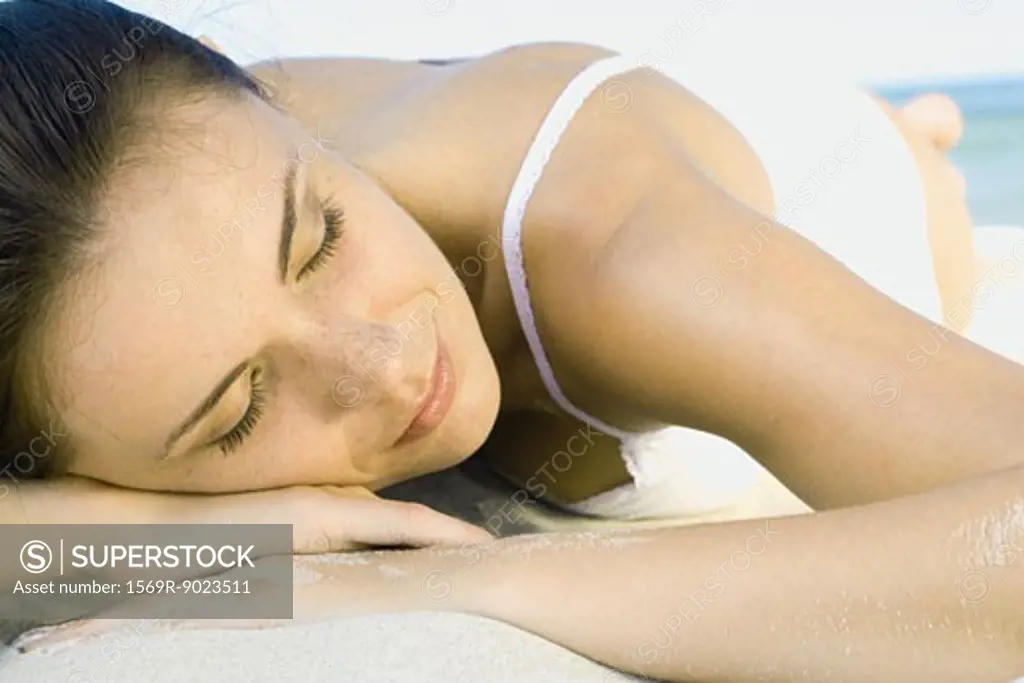 Woman lying on beach, close-up