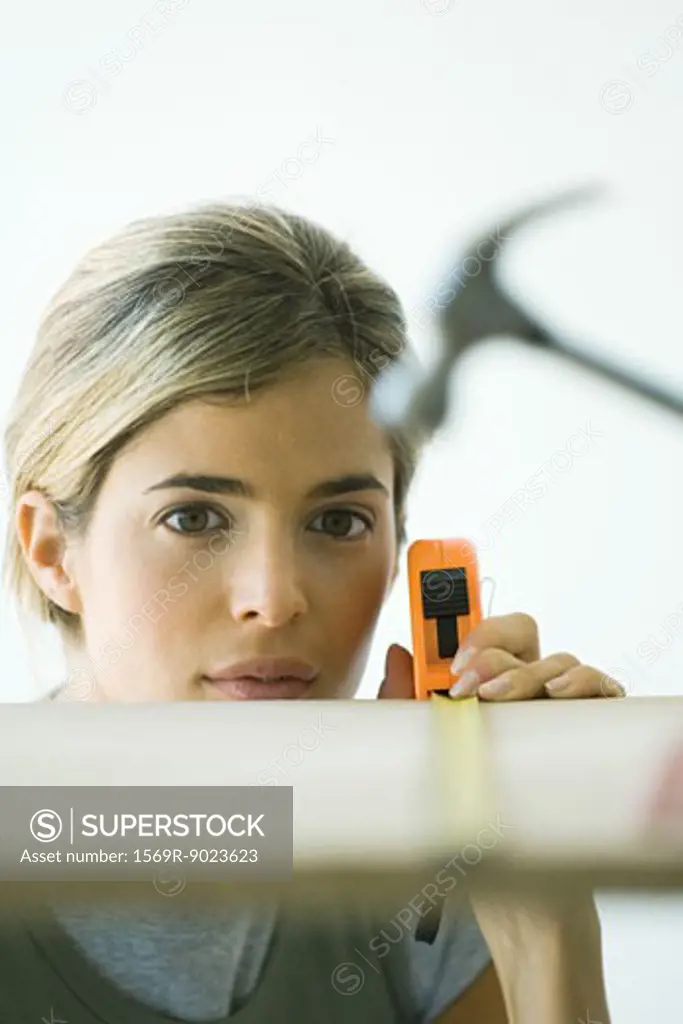 Woman measuring wooden board