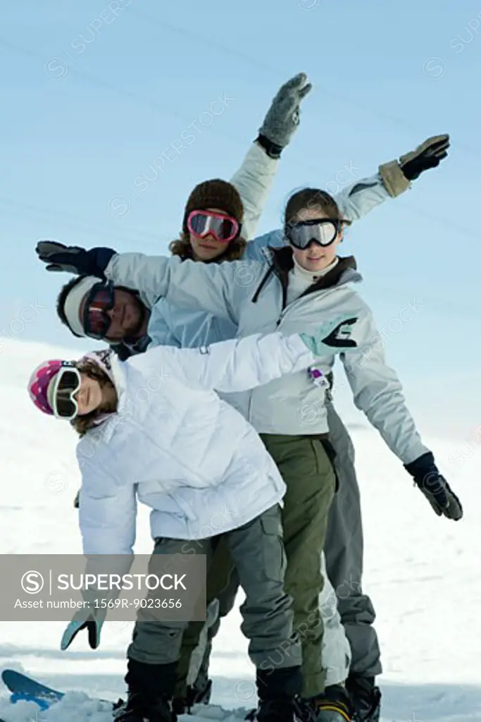 Young skiers standing on ski slope, full length portrait  