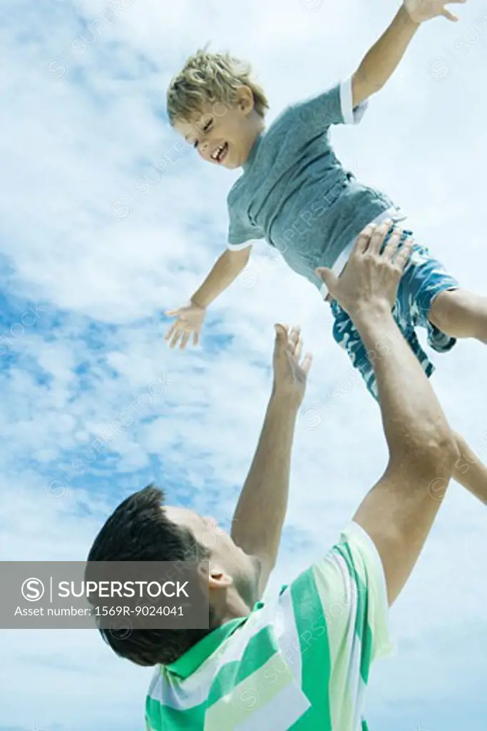 Man throwing child into air