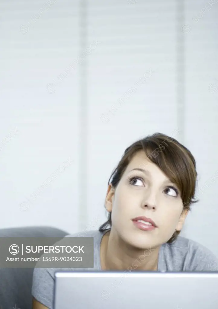 Young woman on couch, using laptop
