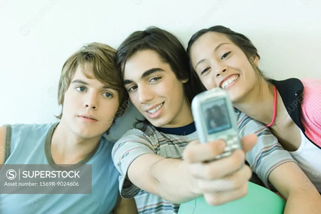 Three teen friends taking self portrait with cell phone