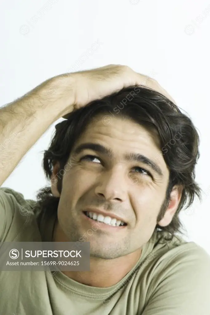 Man holding top of head, wincing, portrait