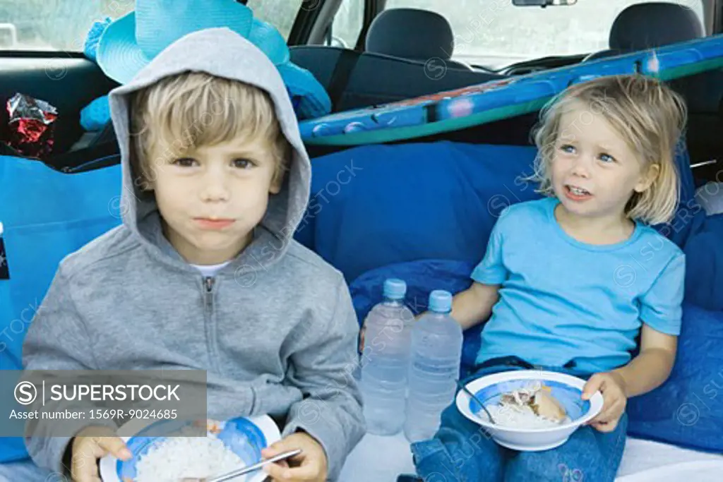 Children eating meal in back of car