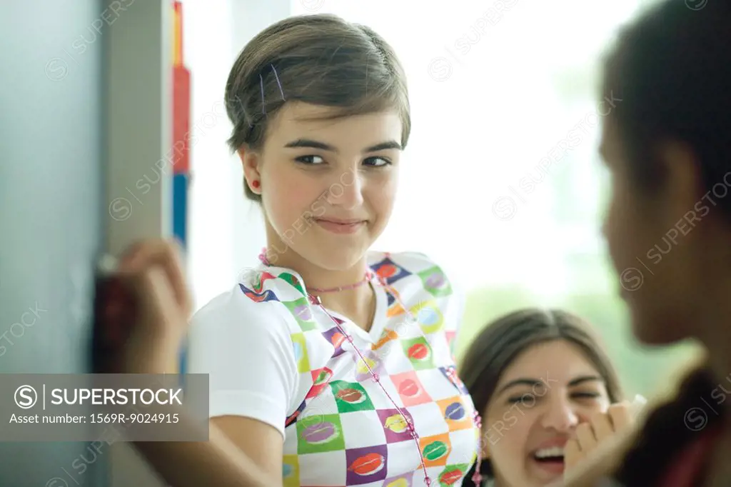 Young female friends writing on chalkboard