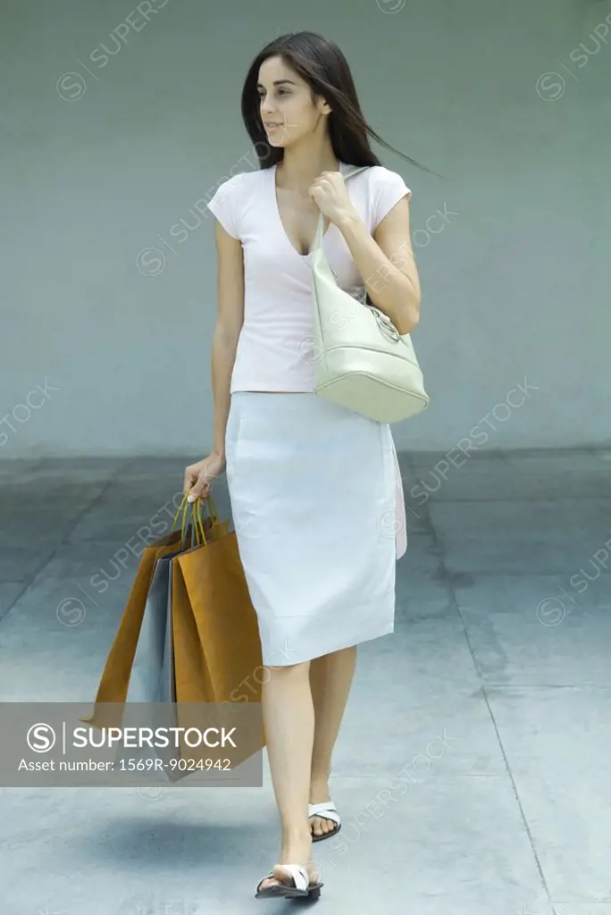 Woman carrying shopping bags, full length portrait
