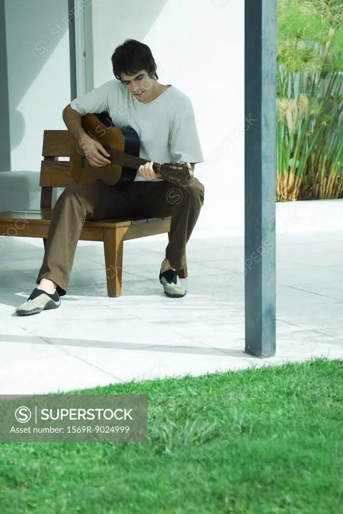 Man playing guitar, full length portrait