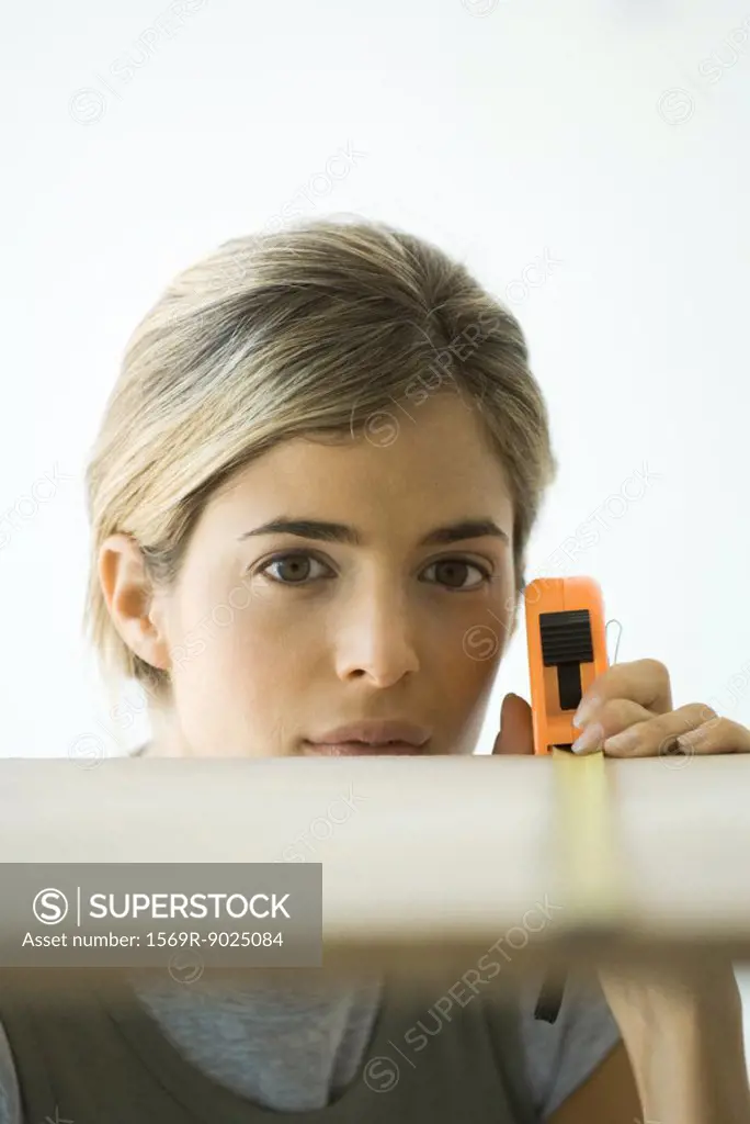 Woman measuring board, focus on woman in background