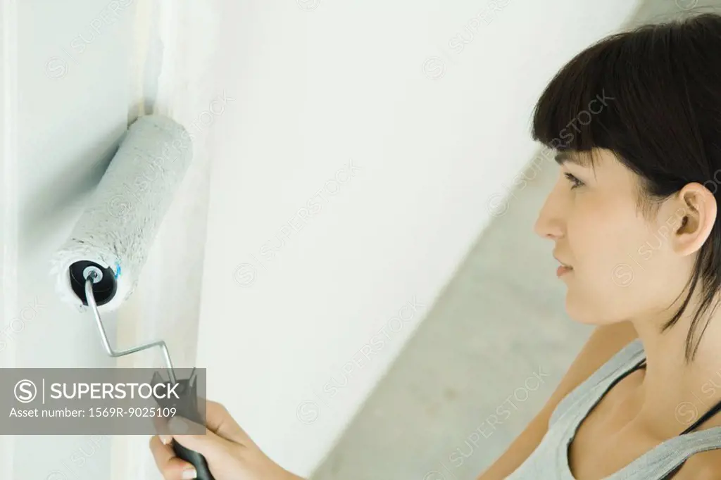 Woman painting door with paint roller