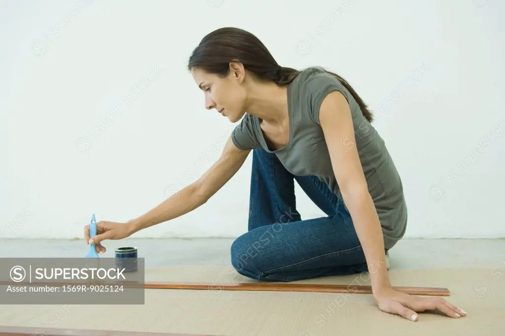 Woman staining slats of wood