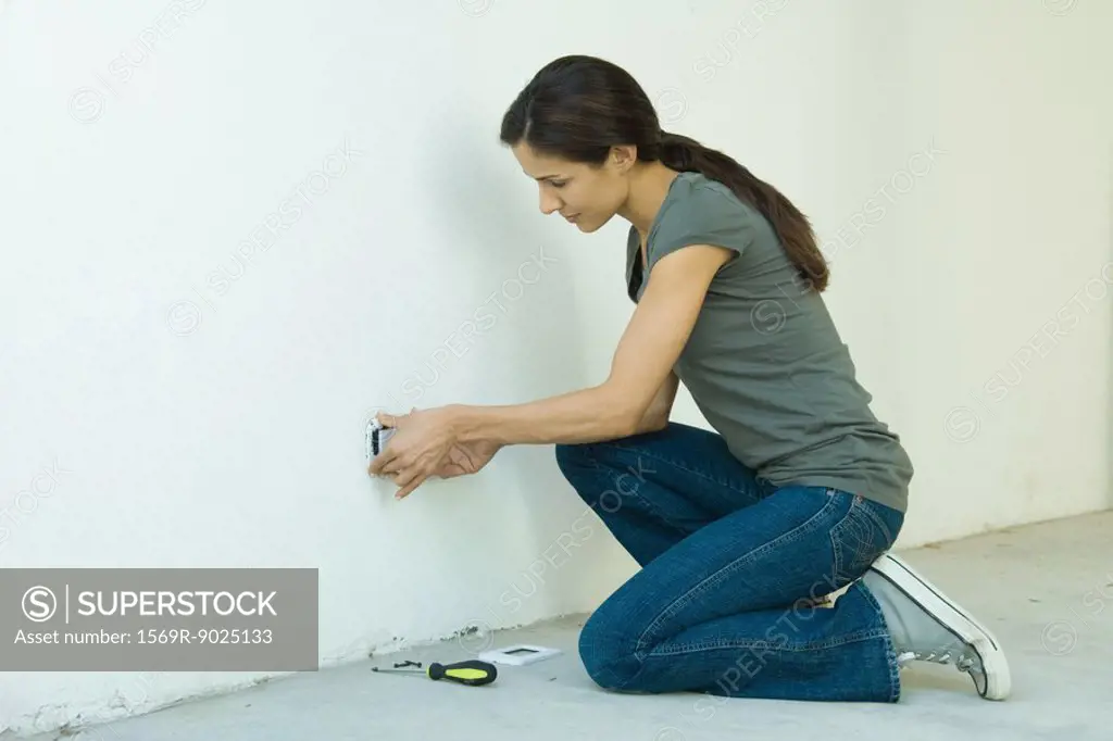 Woman replacing outlet cover