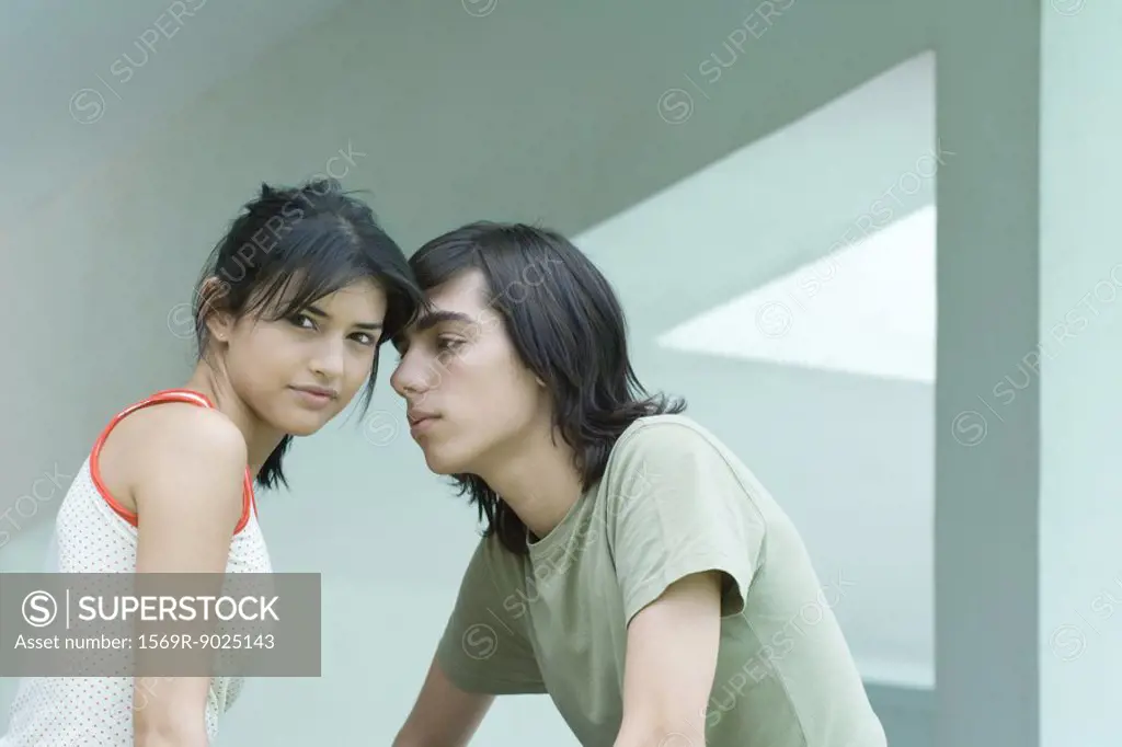 Young couple, female looking at camera while male looks at her