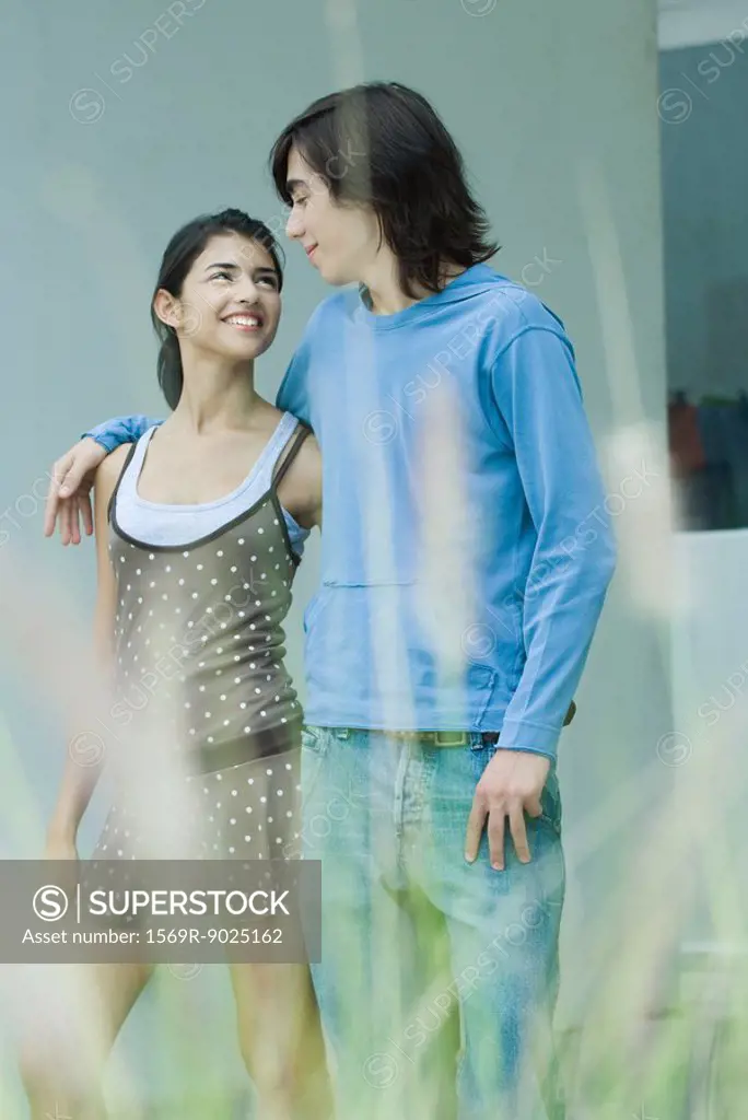 Young couple, smiling at each other, focus on background