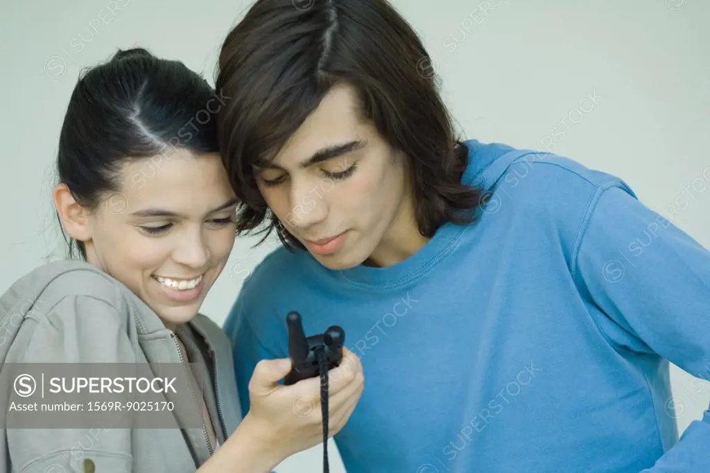 Teen couple looking at cell phone together