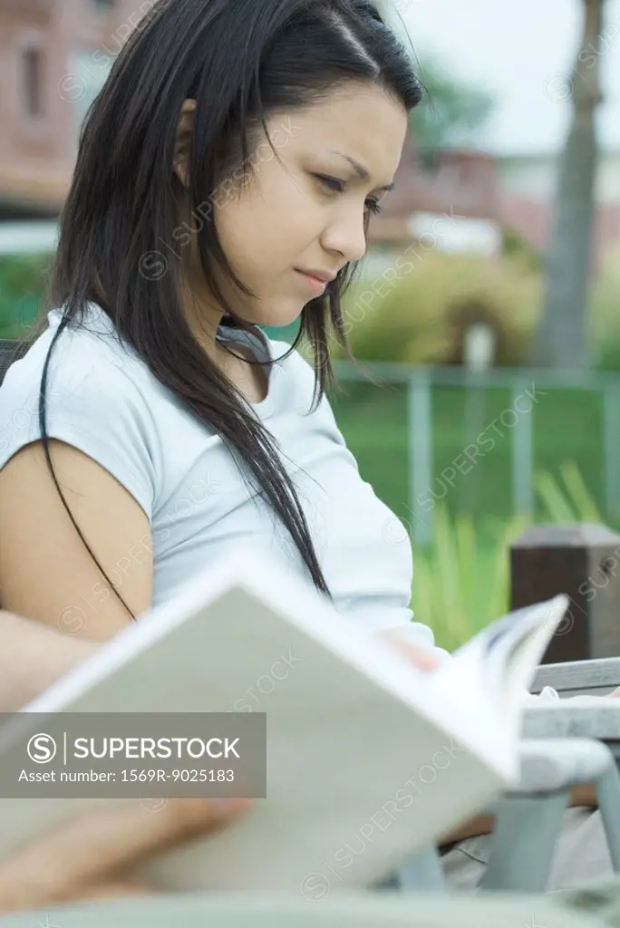 Young woman, book in blurred foreground