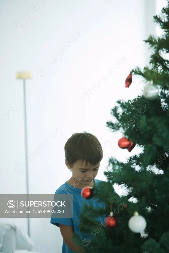 Boy standing by Christmas tree