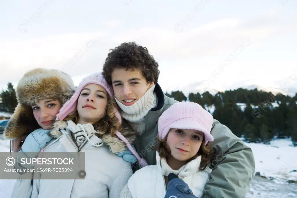 Group of young friends standing in snowy landscape, waist up, portrait