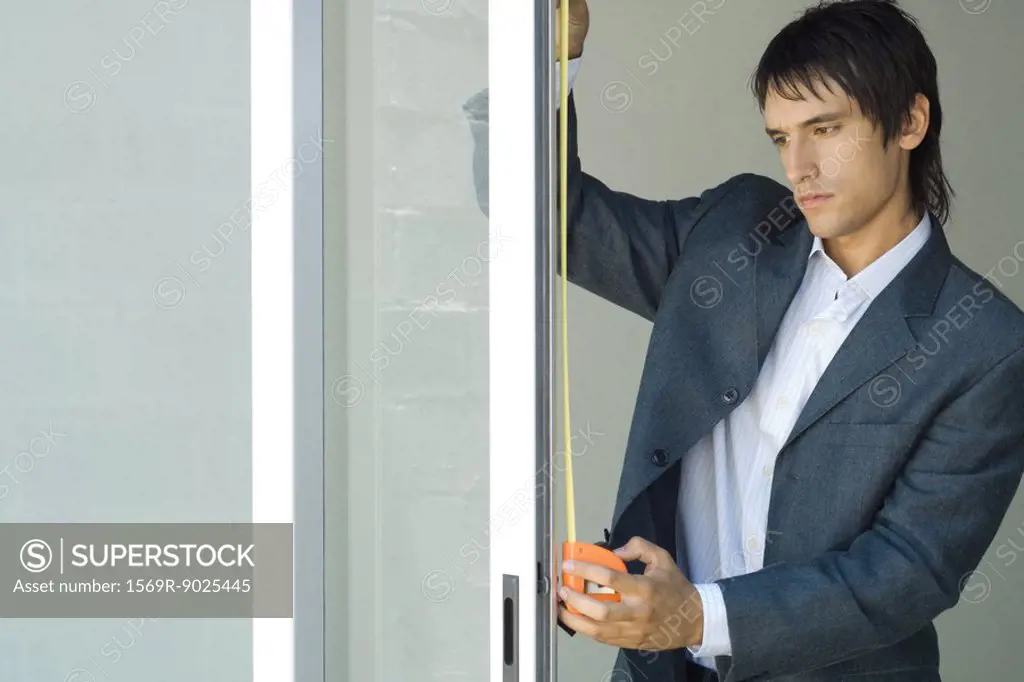 Man measuring sliding glass door