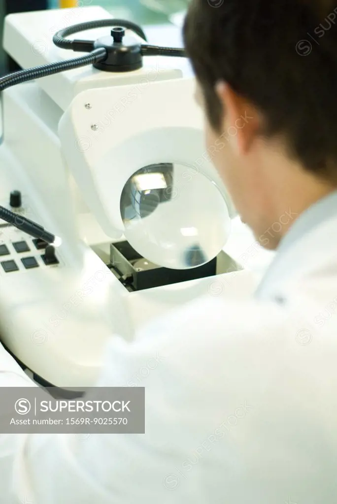 Male lab worker using lab machine, rear view
