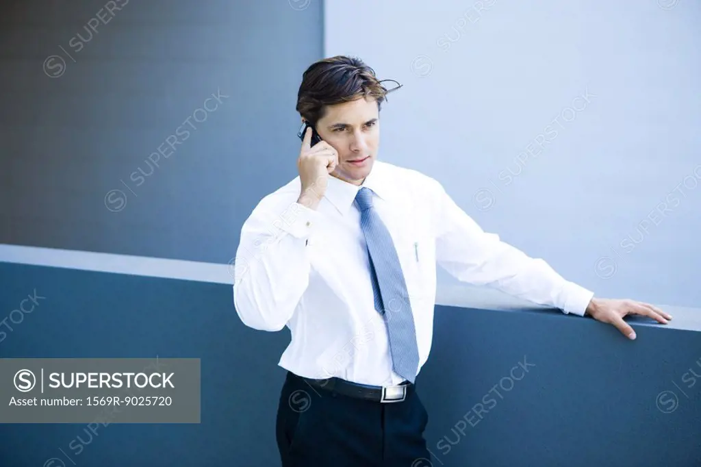 Young businessman using cell phone, waist up