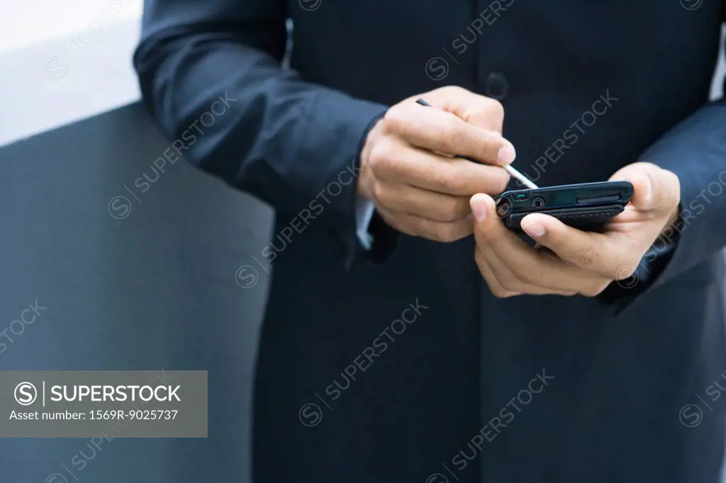 Businessman using palmtop, cropped view of hands