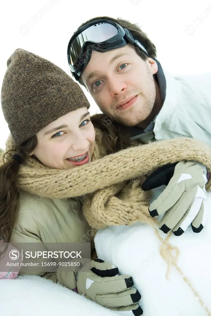 Brother and sister in snow, smiling at camera, portrait