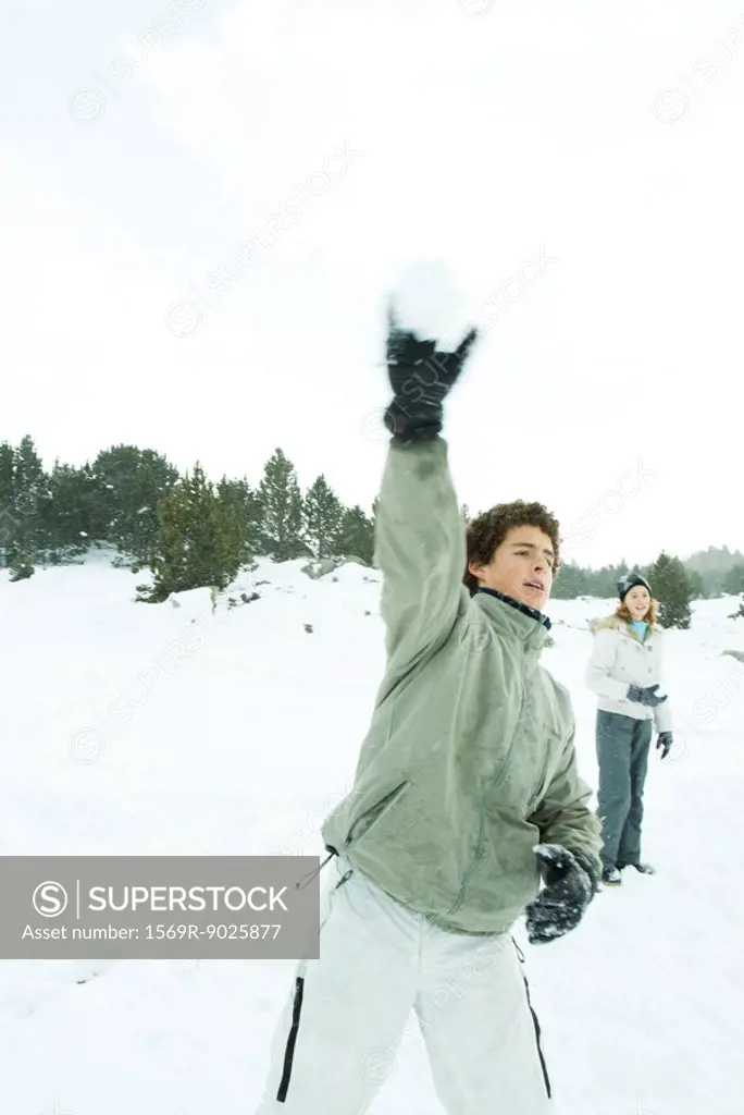 Teenage boy throwing snowball, blurred motion