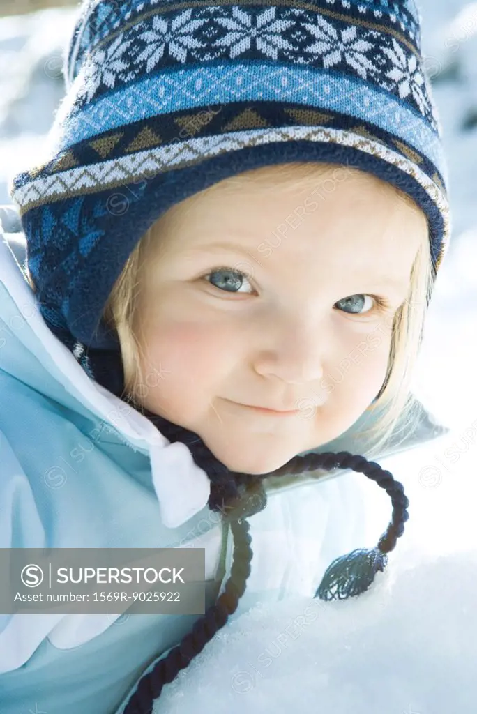 Toddler girl smiling at camera, dressed in winter clothing, portrait