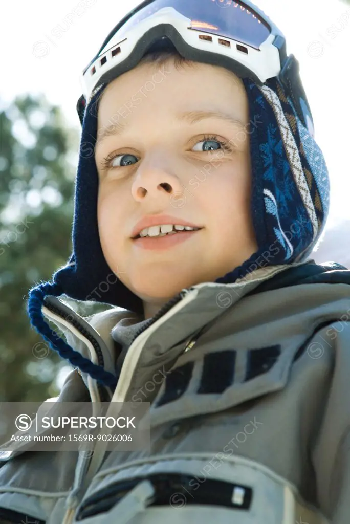 Boy wearing ski gear, looking at camera, low angle view, portrait