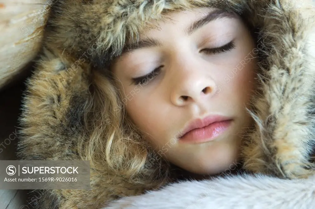 Preteen girl, wearing fur hat, wrapped in fur blanket, sleeping, close-up portrait