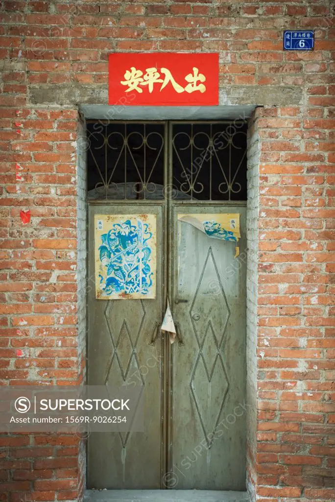 Closed doors with posters on door and banner overhead, China