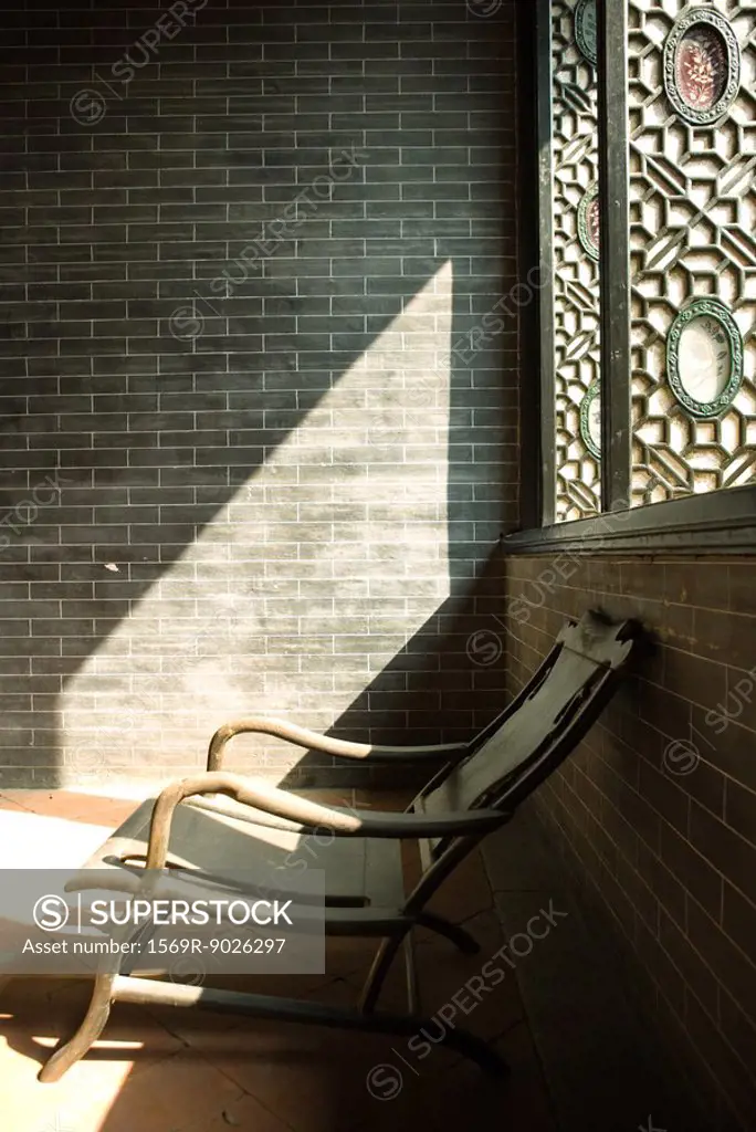 Wooden chair near window, in sun