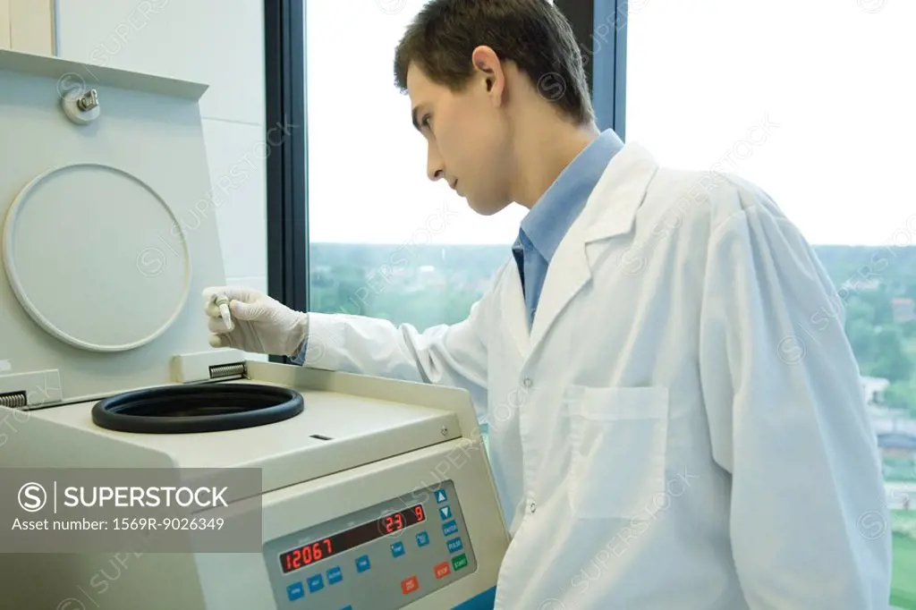 Young male scientist using centrifuge
