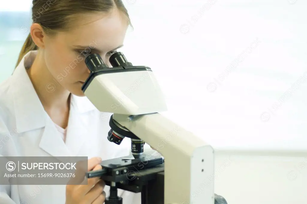 Young woman using microscope