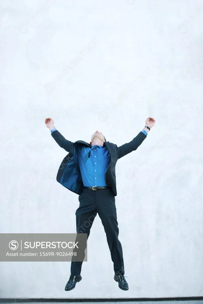 Businessman jumping in air, full length