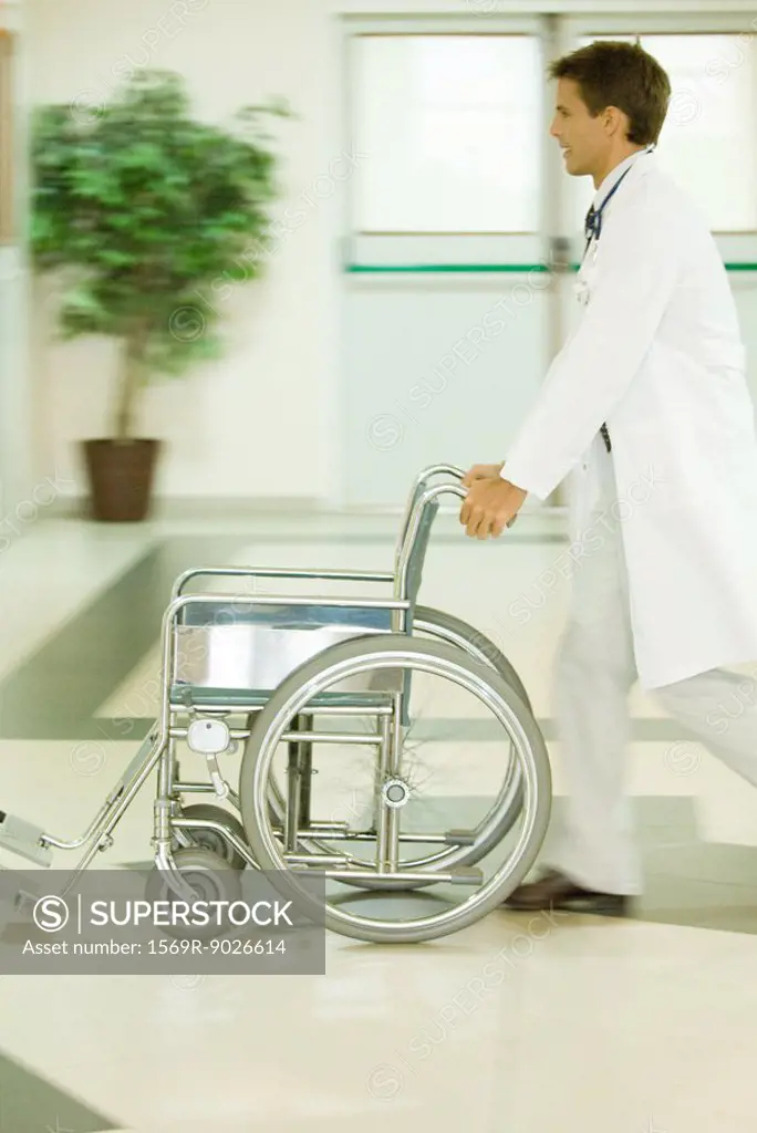 Male doctor pushing empty wheelchair, blurred motion
