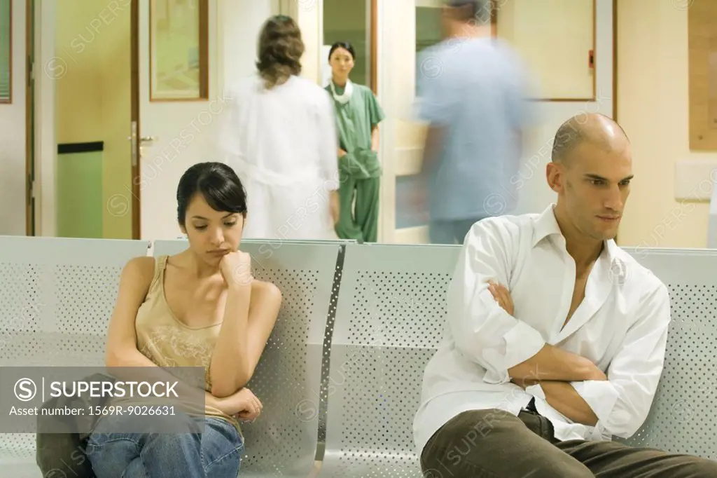 Adults sitting in hospital waiting room, looking away