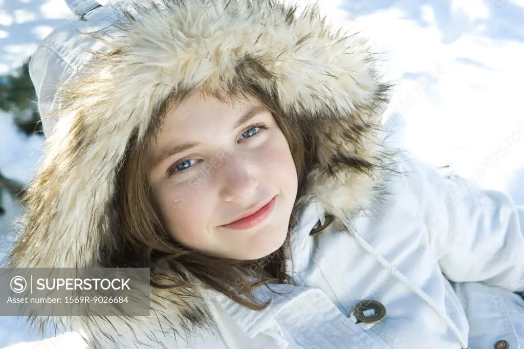 Teenage girl wearing parka in snow, portrait