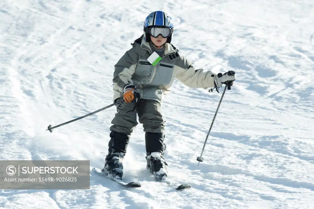 Boy skiing down hill, full length