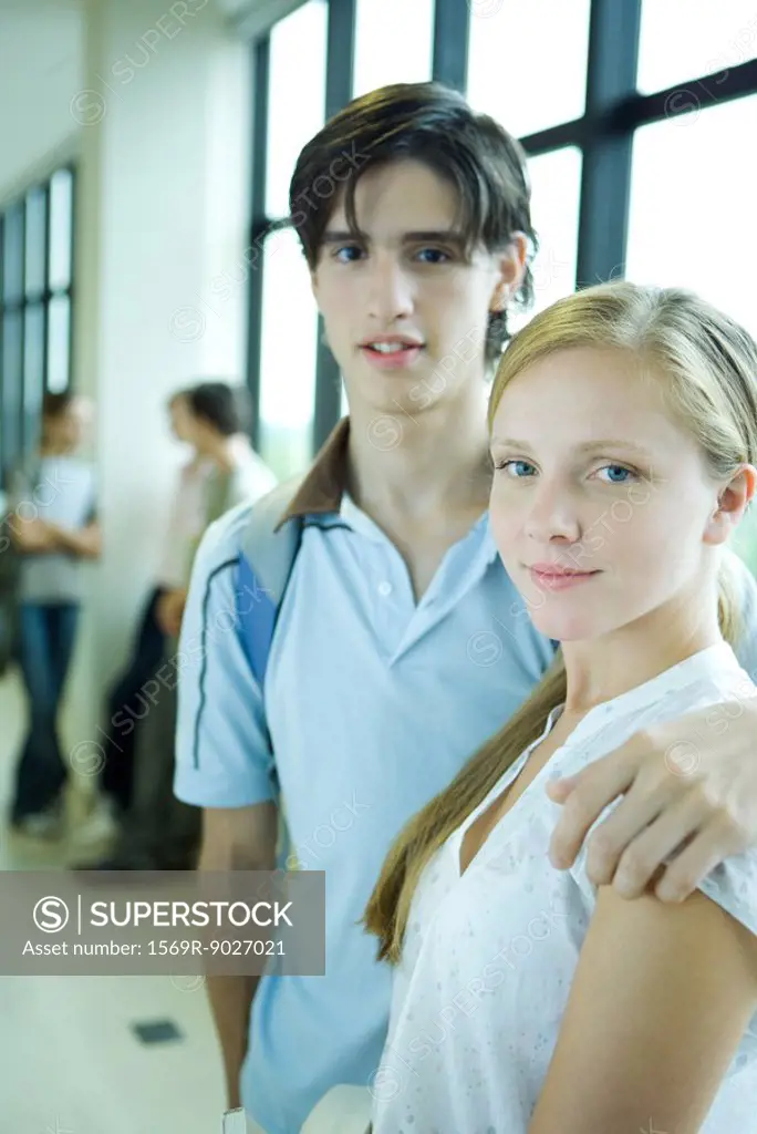 Young couple standing together, one´s arm around the other´s shoulder