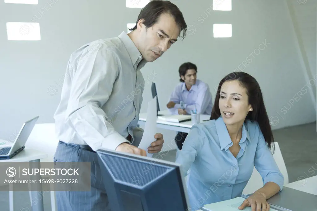 Two business colleagues looking at computer screen together
