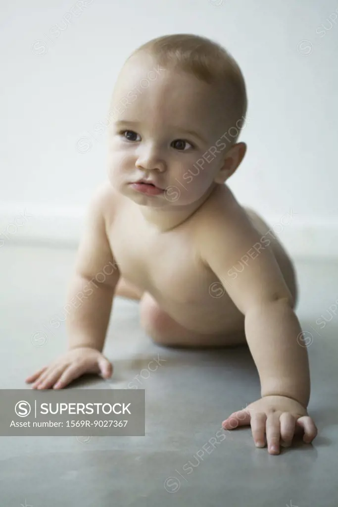 Baby on floor, pushing self up with arms, looking away, portrait