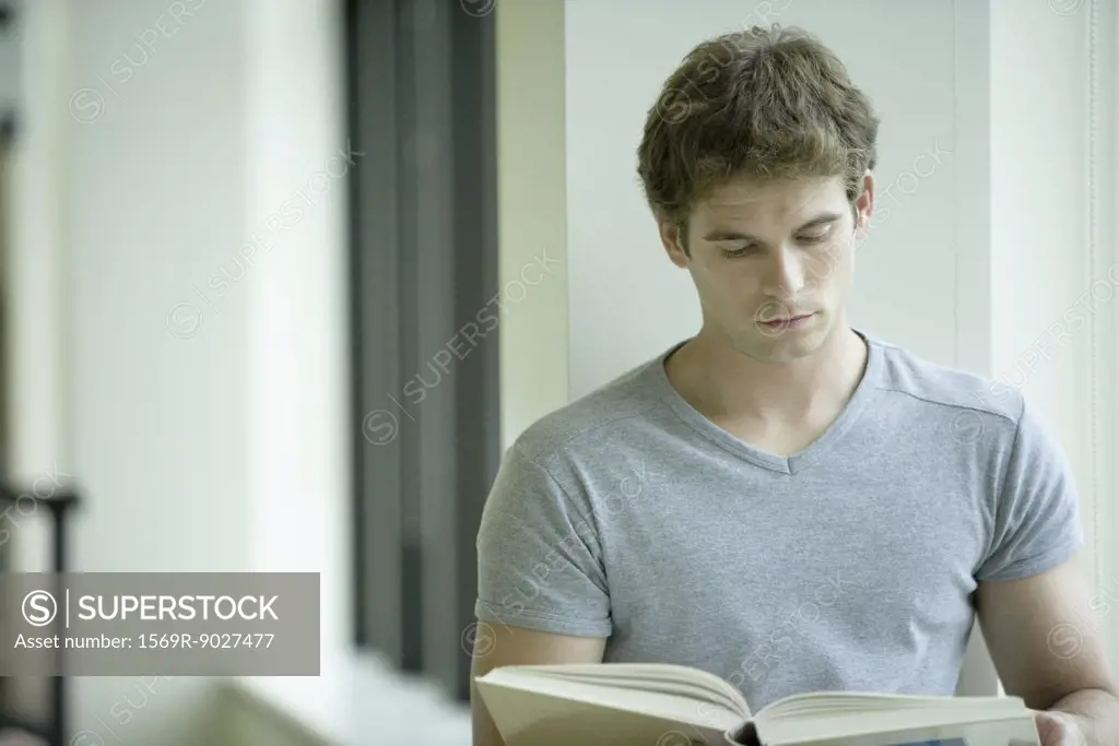 Male college student studying in library