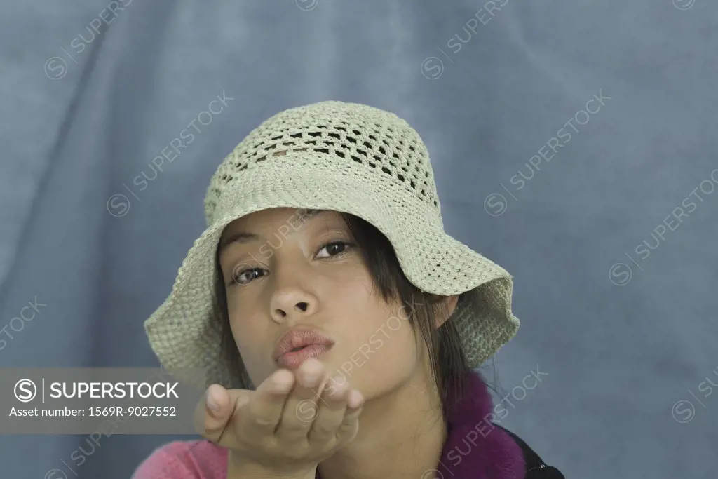 Teenage girl looking at camera, blowing a kiss, portrait