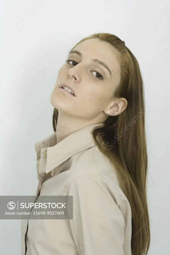 Young woman looking at camera, head back, portrait